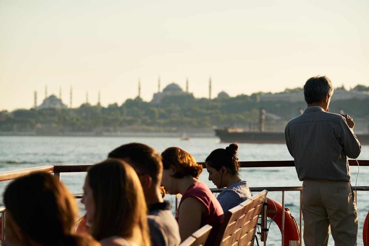 People enjoying a ferry ride with a stunning view of Istanbul's skyline and Bosporus.